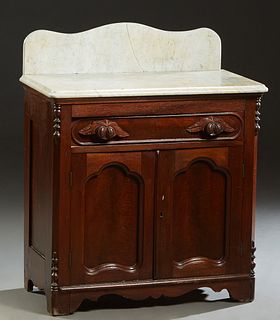 American Carved Walnut Marble Top Washstand, c. 1880 with a figured white marble and a marble back splash, on a base with a long frieze drawer over do