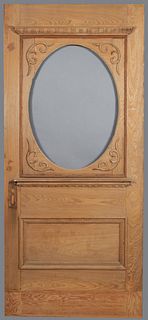 Large Louisiana Carved Cypress Entrance Door, 19th c., the top with an oval cutout for glass, H.- 90 1/2 in., W.- 40 in., D.- 1 1/2 in.