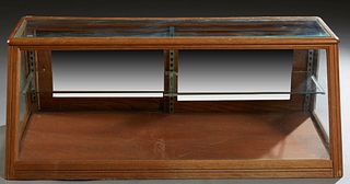 Oak Slant Front Tabletop Display Case, early 20th c., with a glass top, front and sides, the rear with two mirrored sliding glass doors, the interior 