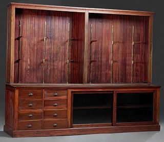 Store Cypress Display Counter, early 20th c., the long rectangular top over eight rear storage drawers next to two sliding doors, on a plinth base, no