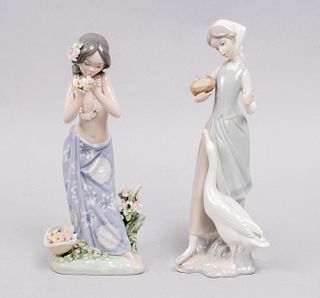 Lote de 2 figuras decorativas. España. Ca. 1970 y 1985. En porcelana Lladró. Acabado brillante. Consta de: niña hawaiana y campesina.