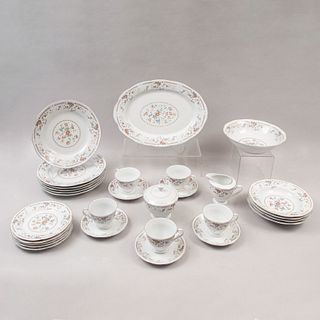 Juego de vajilla. China, siglo XX. Elaborado en porcelana blanca con filos en esmalte dorado y bouquets. Para 8 servicios. Pz: 44