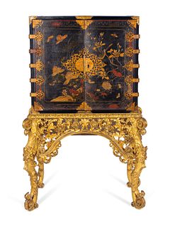 A Chinese Brass-Mounted Gilt-Decorated Black Lacquer Cabinet on Later Giltwood Stand
Height 59 x width 32 1/2 x depth 17 inches.