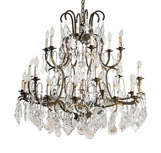 A Louis XV Style Patinated Metal Twenty-Four-Light  Chandelier
Height 35 x diameter 39 inches.