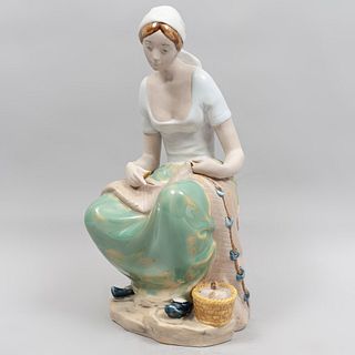 Tejedora de redes España, siglo XX Elaborada en porcelana REX acabado brillante con piel gres. 32 cm de altura