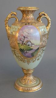 Large Nippon Porcelain Vasehaving enameled jewels and heavy gilt decorations, oval painted landscape panels on each side and gilt handlesall on pede