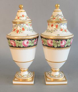Pair of French Porcelain Urns
each with cover and painted with flowers and gilt bands
height 14 inches
(repaired covers)
