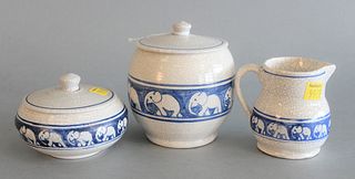 Three Dedham Pottery Pieces 
with elephant border, two covered jars and a creamer
having crackle glaze with blue Dedham Pottery stamp on bottom
jar he