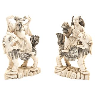 PAIR OF CHARACTERS ON FU DOGS. ASIA, CA. 1900. Ivory carved and inked with decorative floral motifs 5.9" (15 cm)