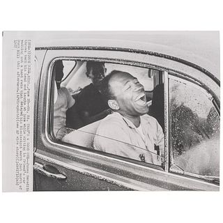 [MEREDITH, James H. (b. 1933)]. Press photograph of Meredith in a car, laughing while waiting out a hard rain that delayed his Mississippi march. Duck