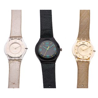 Tres relojes Swatch. Movimiento de cuarzo. Cajas de aluminio. Carátulas beige, blanco y negro. Correas Tela y polímero.
