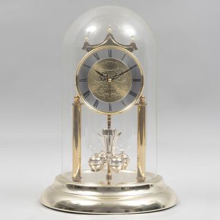 Reloj de torsión. Alemania, siglo XX. Mecanismo de cuarzo. Marca Royal. Elaborado en resina dorada, latón y capelo de vidrio.