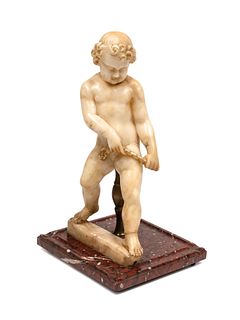 A Continental Carved Marble Figure of a Putto on a Red Marble Base