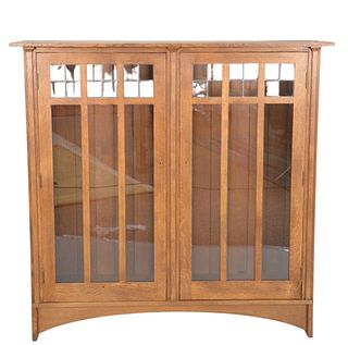 Stickley Mission Oak Two Door Bookcase, having leaded top panels, height 58 1/2 inches, full width 59 inches, exterior depth 13 inches.