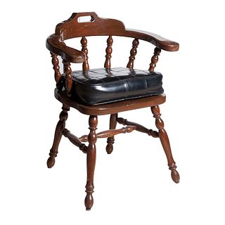 Sillón. Siglo XX. En talla de madera. Con respaldo semiabierto, asiento con cojín tipo piel color negro.