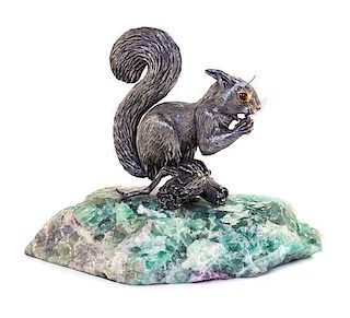 A Italian Silver Model of a Squirrel, 20th Century, depicted seated on a branch eating a nut, set on a quartz base.