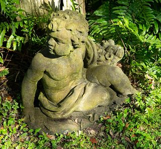 A Pair of Cast Stone Seated Putti
Height 21 1/2 x width 24 x depth 10 inches.
