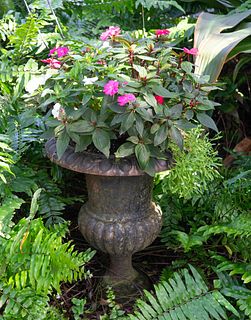 A Pair of Cast Iron Campana-form Garden Urns on Pedestals
Height 27 x diameter 15 inches.