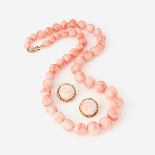 A coral and fourteen karat gold necklace with matching ear clips,