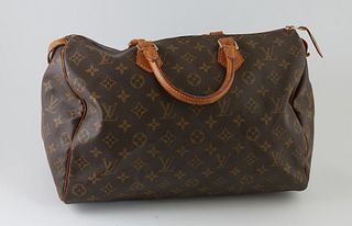 Louis Vuitton Brown Monogram Coated Canvas 35 Speedy Handbag, with golden brass hardware, opening to a light brown canvas lined interior with a small 