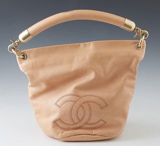 Chanel Nude Leather Bucket Bag, c. 2003-2004, the exterior with stitched Chanel logo and frosted gold metal accents, the metal Chanel pull zipper open