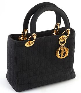 Christian Dior Black Cannage Canvas Lady Dior Handbag, with golden brass accents and hanging "D-i-o-r" keychain, opening to a red interior with side z