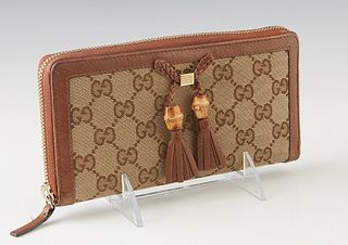 Gucci Bamboo GG Canvas Zippy Wallet, with gold tone hardware and two braided leather bamboo tassels, the interior lined in brown leather with numerous