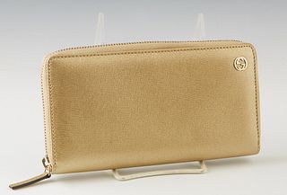 Gucci Gold Leather Wallet, with gold tone hardware and zip closure, the interior lined in gold leather and brown canvas with numerous card slots and a