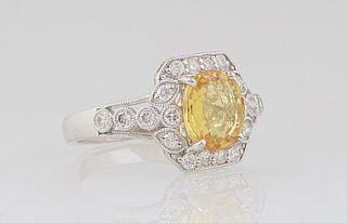 Lady's Platinum Dinner Ring, with a cushion cut 2.05 ct. yellow sapphire atop a round diamond mounted border, the shoulders of the band also mounted w
