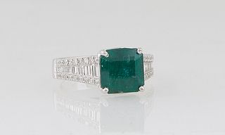 Lady's 18K White Gold Dinner Ring, with a 3.35 ct. square emerald atop graduated shoulders with a central row of baguette diamonds, flanked by edge r