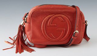 Gucci Red Orange Grained Leather Soho Disco Bag, with gold tone hardware and a zip closure with tassel, the interior of the bag lined in beige canvas 