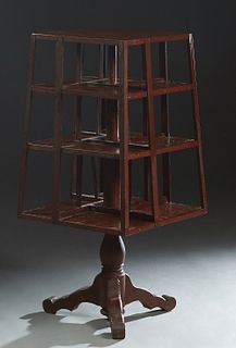 American Carved Mahogany Revolving Bookmill, early 20th c., with slatted sides, on a circular support to tripodal flat splayed legs, H.- 44 in., W.- 1