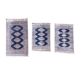 Lote de 3 tapetes, pie de cama. Siglo XX. Estilo bokhara. Elaborados en fibras de lana y algodón. Decorados con motivos geométricos.