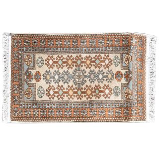 Tapete, pie de cama. Siglo XX. Estilo turcomano. Elaborado a en fibras sintéticas. Decorado con elementos geométricos.