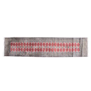 Tapete de pasillo. Siglo XX. Estilo bokhara. Elaborado en fibras sintéticas. Decorado con motivos geométricos en color carmín.