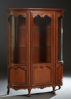 French Louis XV Style Carved Cherry Demilune Curved Glass Vitrine, early 20th c., the stepped rounded edge top over a center door with a glazed upper 