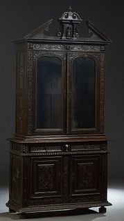 French Henri II Style Carved Walnut Buffet a Deux Corps, 19th c., the broken arch figural carved pediment over a stepped crown and double glazed doors