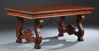 French Renaissance Style Drawleaf Dining Table, 20th c., the carved rounded edge top over a carved skirt, with two draw leaves, on large paw foot tres