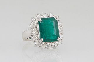 Lady's 18K White Gold Dinner Ring, with a 6.43 ct. emerald atop a border of round diamonds, total diamond wt.- 1.34 cts., Size 5 1/2, with appraisal.