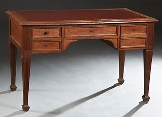 French Carved Oak Art Nouveau Desk, c. 1900, the stepped rounded edge rectangular top with an inset red leather writing surface over a central frieze 