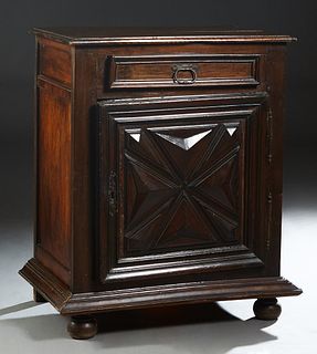 French Provincial Louis XIII Style Carved Oak Confiturier, 19th c., the stepped rounded edge top over a frieze drawer and a lower cupboard door with i