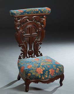 French Carved Oak Prie Dieu, 19th c., the curved upholstered arm rest over an elaborately carved cross and scroll back, to a bow front kneeler, on cab