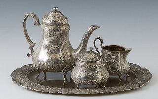 German .800 Silver Four Piece Solitaire Tea Set, late 19th c., consisting of a teapot, creamer, covered sugar, and tray, all with repousse scroll, flo