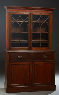 English Carved Mahogany Bookcase Cupboard, early 20th c., the ogee crown over double Gothic glazed mullioned doors, on a base with a fall front secret