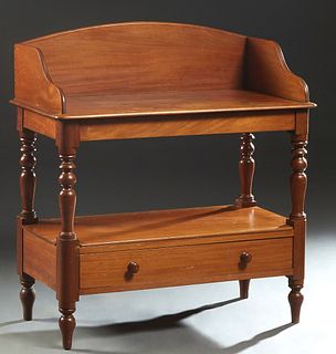 American Carved Mahogany Washstand, late 19th c., the arched back splash over a rounded edge and corner rectangular top, on turned legs to a lower she