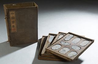 A Cased Set of Chinese Inkstones, early 20th c., of book form, opening to four fitted removable trays of 8 inkstones each, Book- H.- 3 3/4 in., W.- 9 