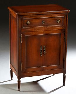 French Provincial Louis XVI Style Carved Cherry Confiturier, 20th c., the ogee edge rounded corner top over a frieze drawer and a double cupboard door