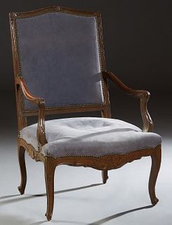 French Carved Walnut Louis XV Style Fauteuil, early 20th c., the arched canted rectangular back to scrolled leaf carved arms, over a bowed seat, on sc