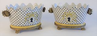 Pair of Porcelain Cachepots, with painted and enamel decoration, on brass stands with paw feet, length 11 inches, height 6 inches.