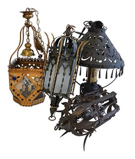 Four Gothic Revival Hanging Lanterns, to include one wrought iron, one painted tole with glass shades, one brass with beveled glass panels and jeweled